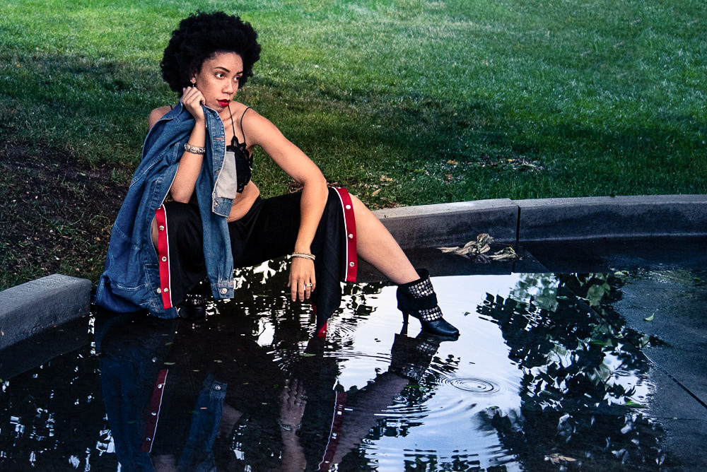 African American girl with beautiful afro squats near puddle of water. Alyssa Bryn Photography. Bryssa. Bryssa Blog.