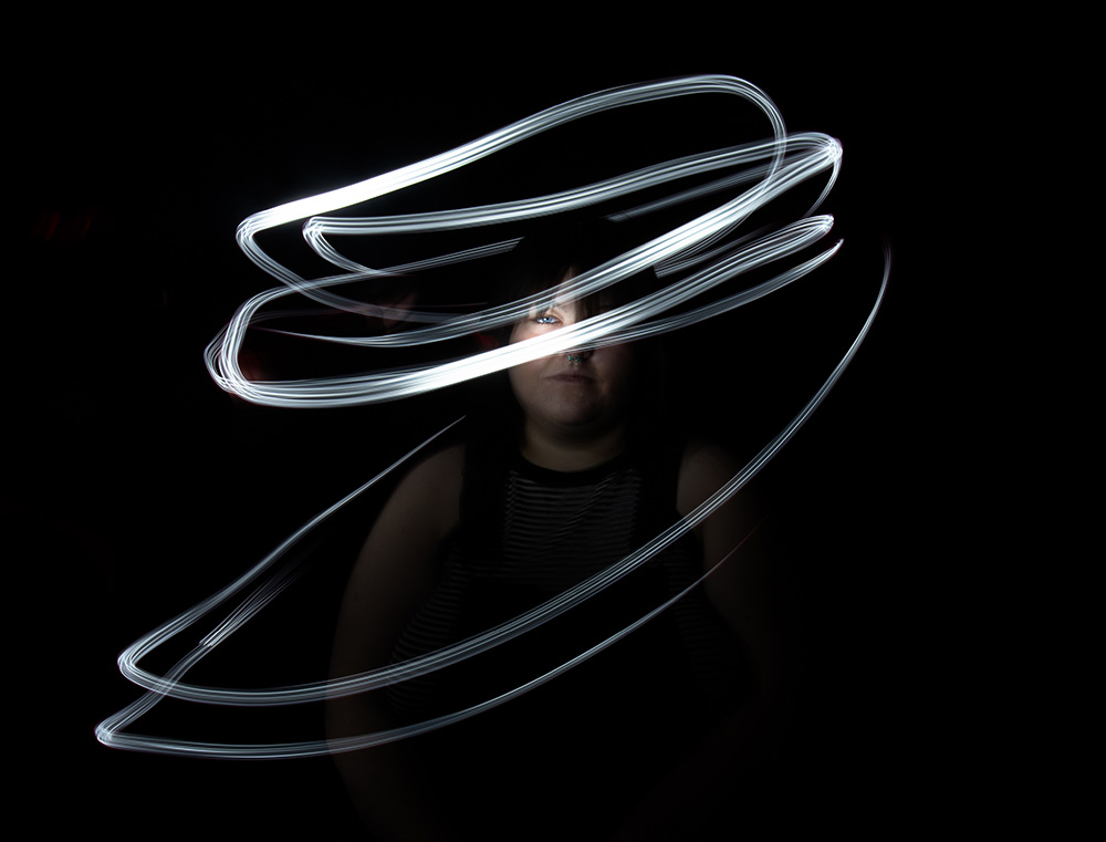 Dark hair blue eyes girl sits with white light painted around her. Alyssa Bryn Photography. Bryssa. Bryssa Blog.