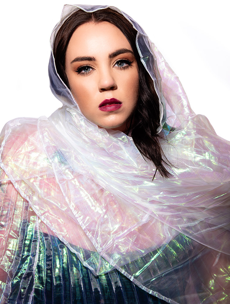 Dark hair blue eye girl wearing red lipstick wrapped in milticolor plastic like material. Alyssa Bryn Photography. Bryssa. Bryssa Blog.