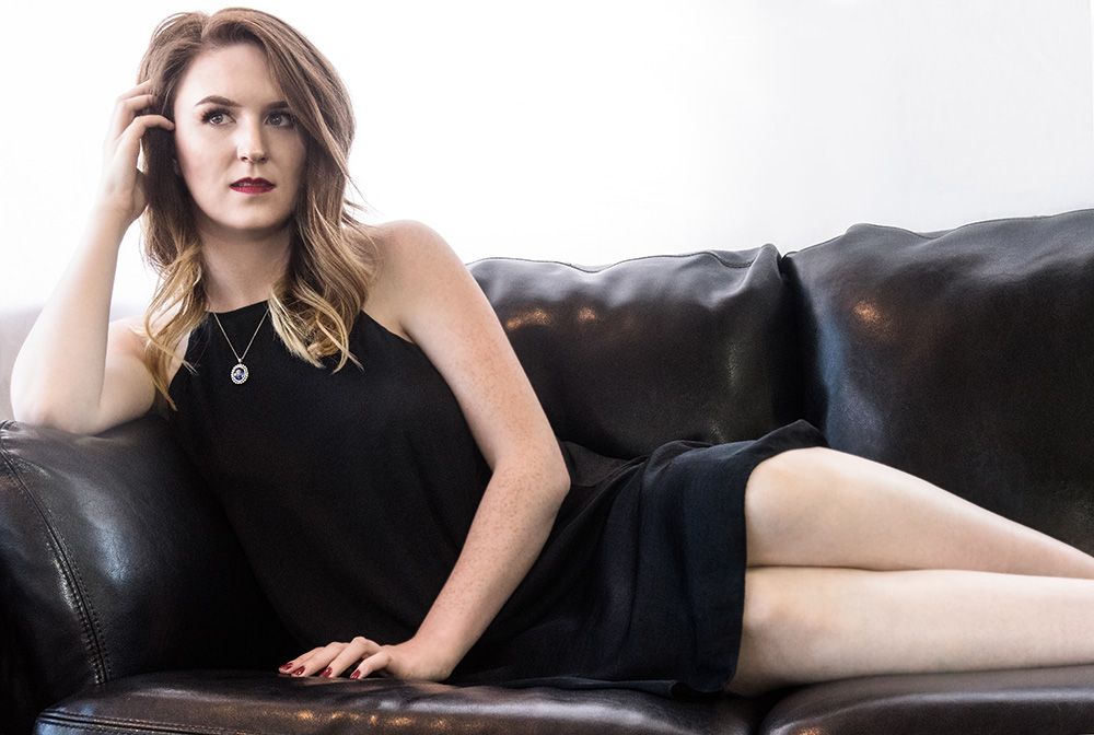 Red hair girl lounging on couch in black dress wearing Purvis neckless. Alyssa Bryn Photography. Bryssa. Bryssa Blog.