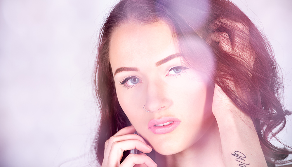 Dark hair blue eyed girl wearing pink lipstick and silver nose ring posing with strands of pink glass beads. Alyssa Bryn Photography. Bryssa. Bryssa Blog.