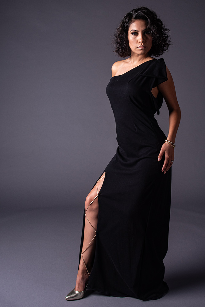 Dark curly hair gail in long black dress with thigh slit heald together with gold chain. Alyssa Bryn Photography. Bryssa. Bryssa Blog.